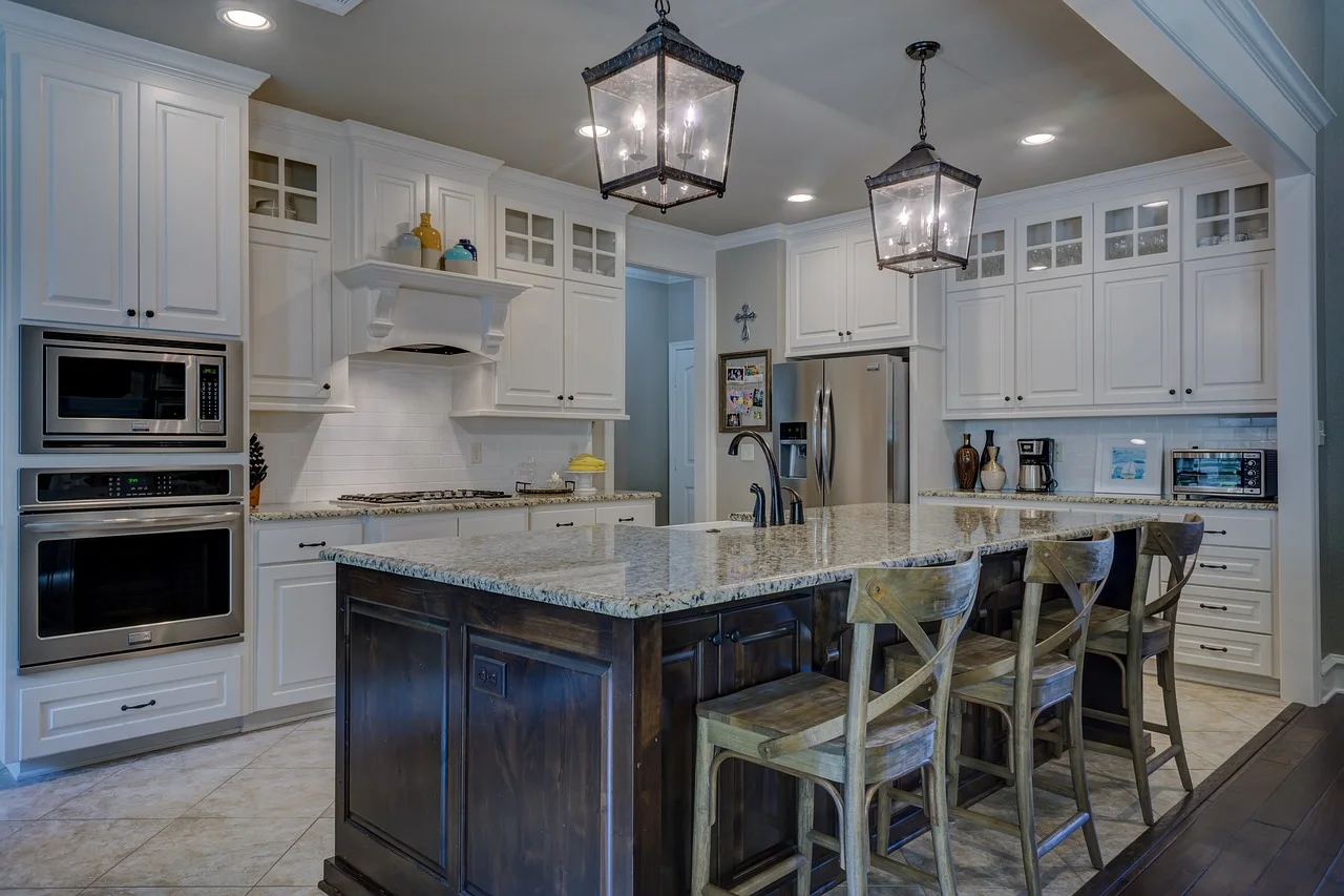 Spacious kitchen with granite countertop island, cabinetry, and countertop small electrical appliances including toaster oven and coffee maker