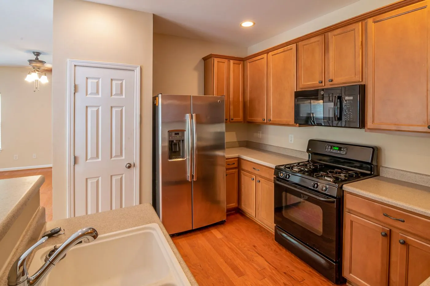 Galley kitchen with a gas range, integrated dishwasher and a large fridge at the far end