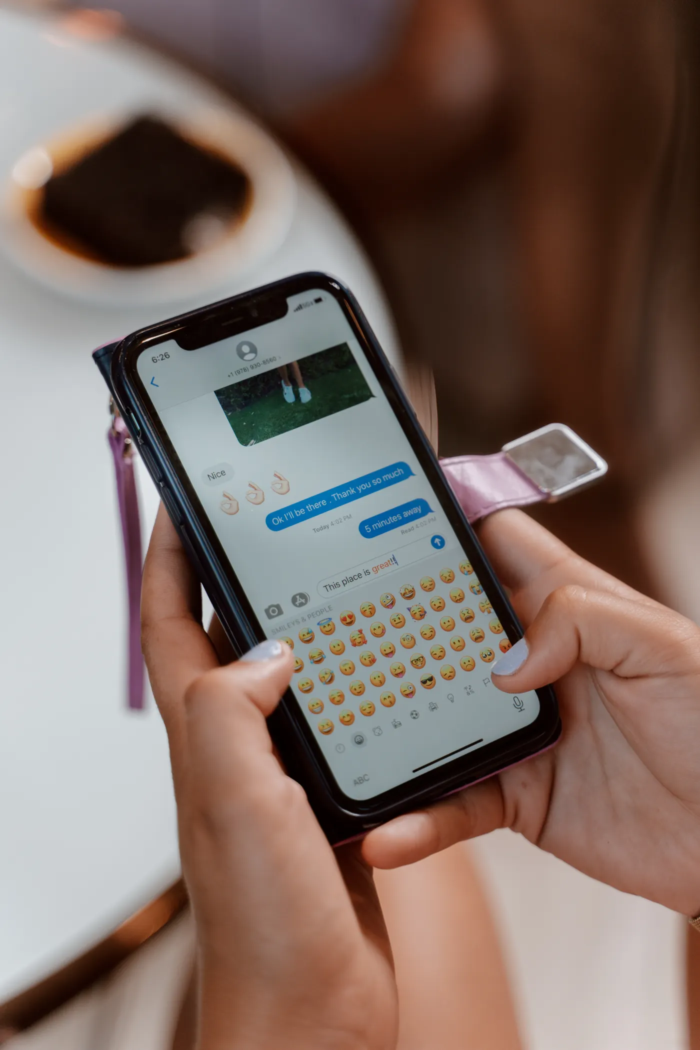Close-up of a person's hands typing a message on a smartphone to arrange a junk removal price in Dubai