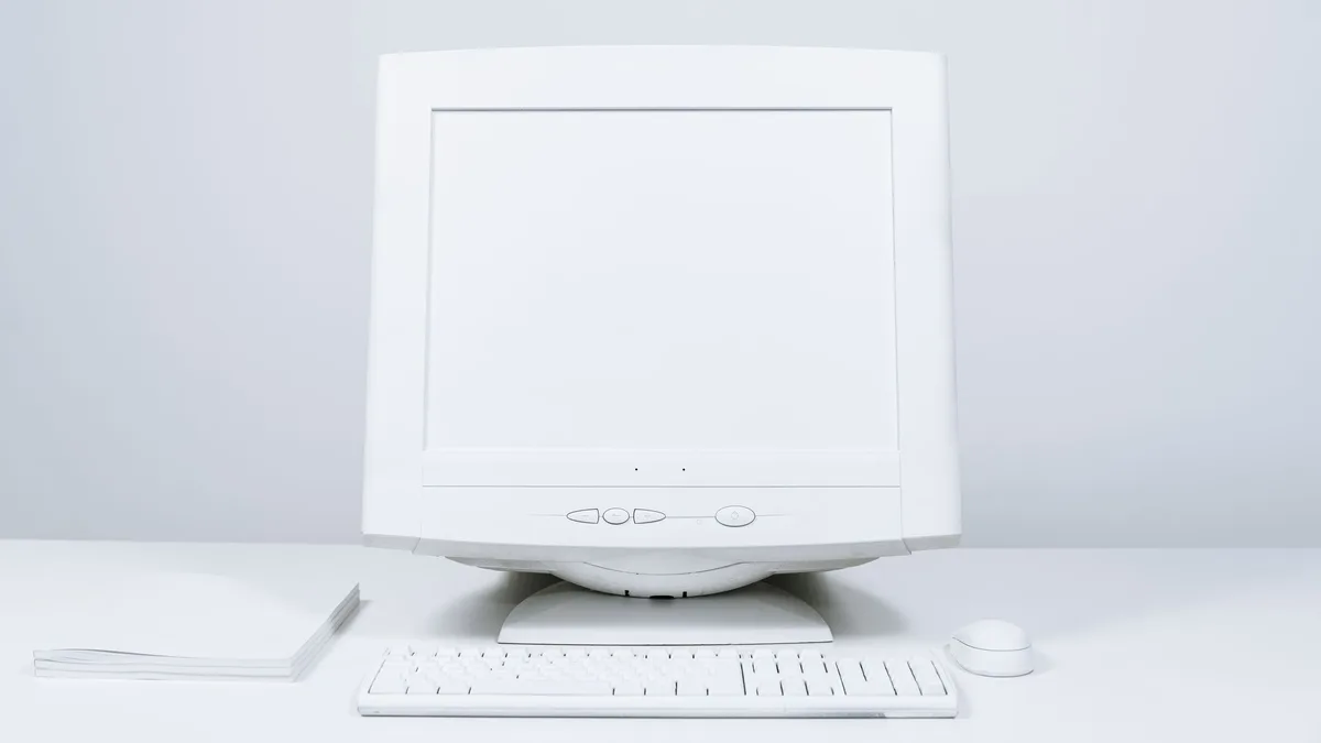 Old home desktop computer, CRT monitor and keyboard on a desk ready for PC disposal in Dubai