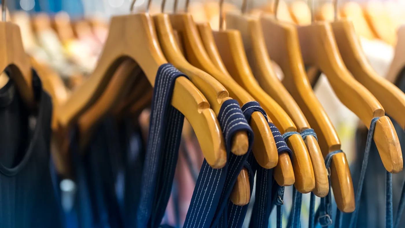 Organized modern wardrobe with clothes neatly arranged on hangers and sorted by garment type