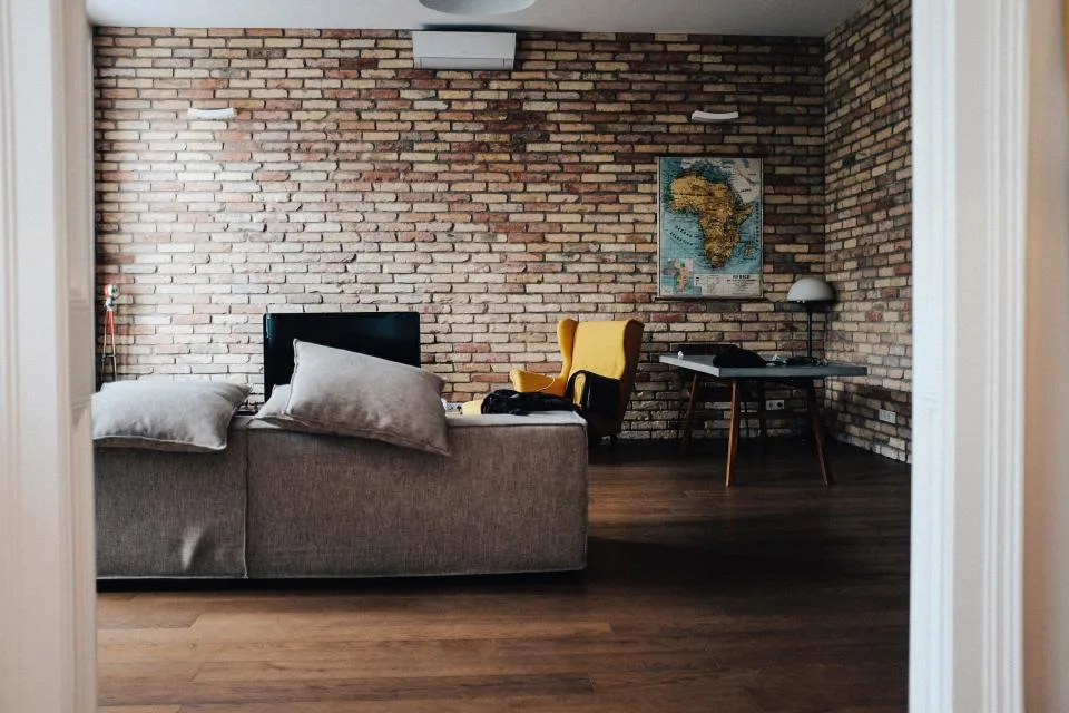 Tidy, uncluttered living room with a sofa and armchair beside a clear open walkway
