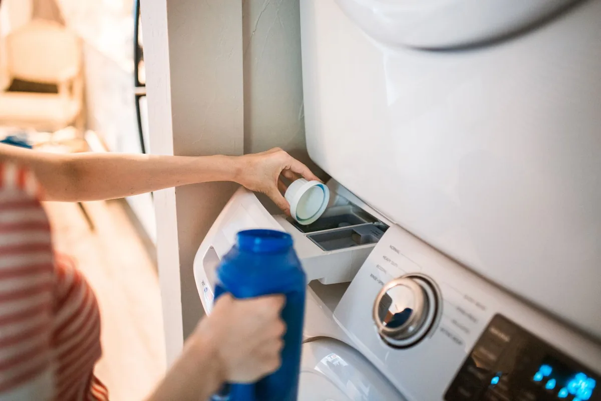 Stacked washer-and-dryer unit in a Dubai home laundry being prepared for professional dryer removal and appliance collection