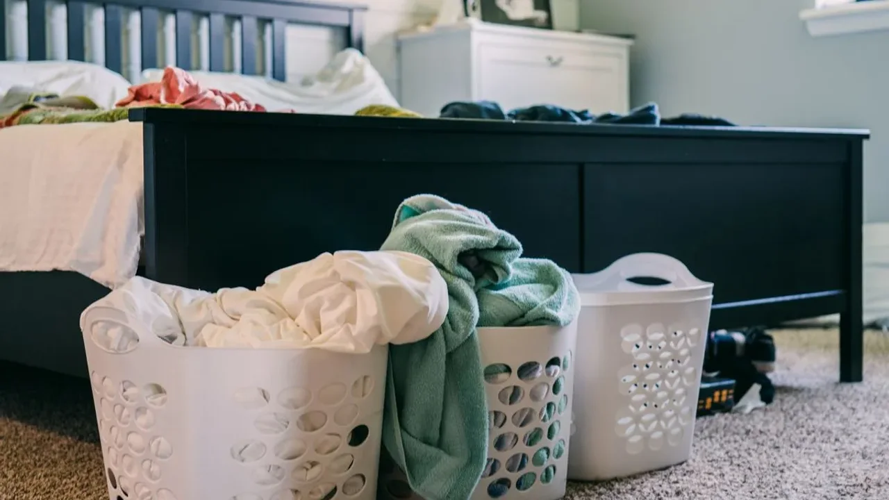 Laundry baskets filled with towels and bedding in a bedroom laundry area