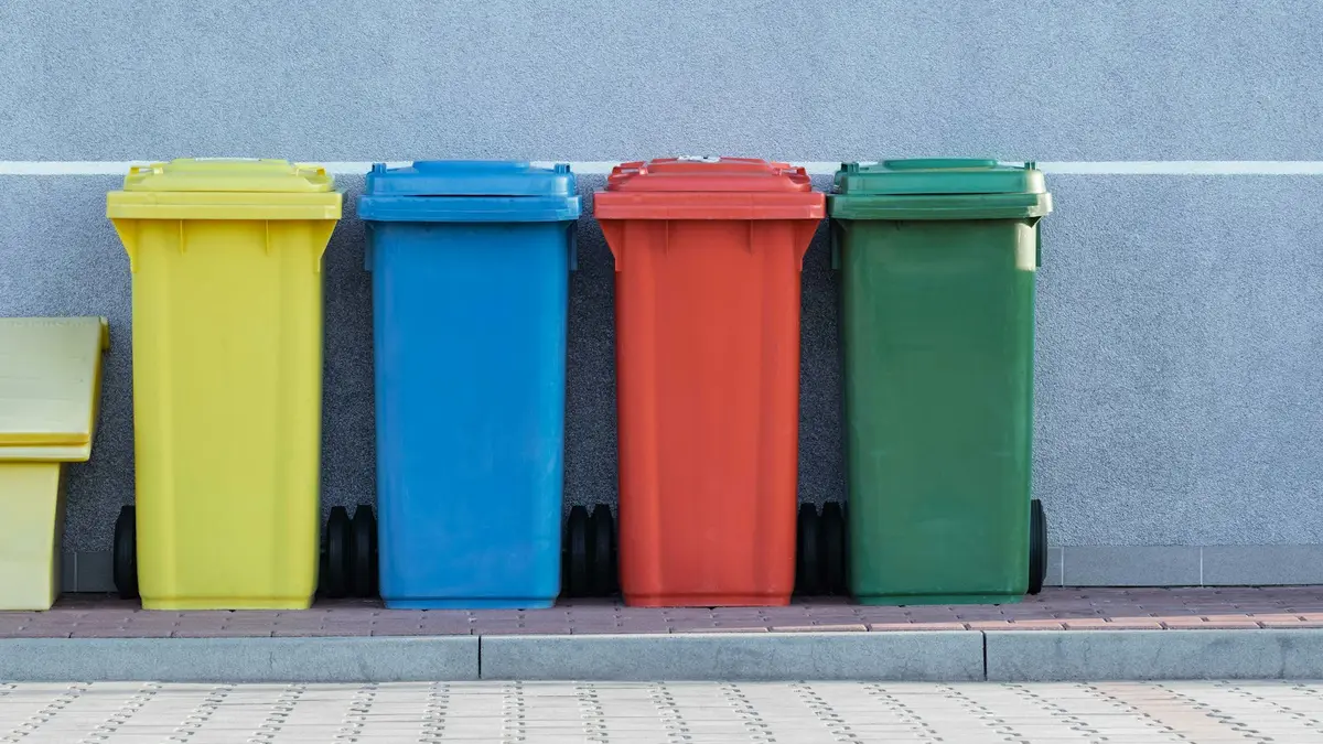 Row of colour-coded wheelie bins against a wall in Dubai, ready for reliable household and commercial garbage collection
