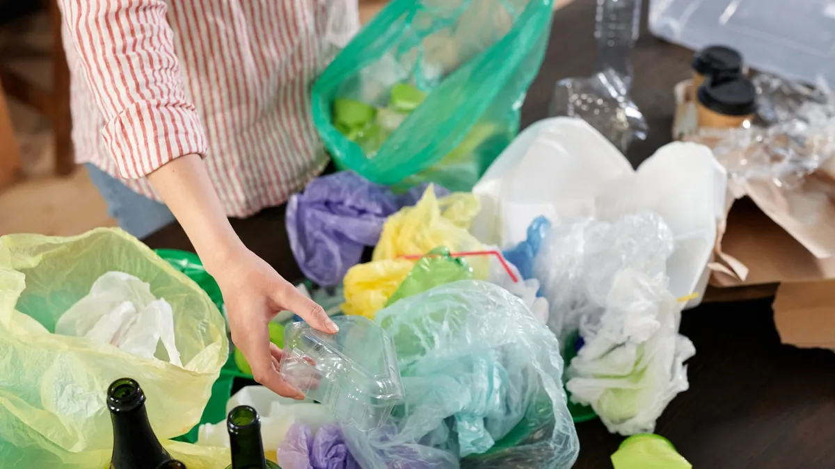 Hands sorting recyclable plastics, bottles and packaging from household waste for recycling in Dubai