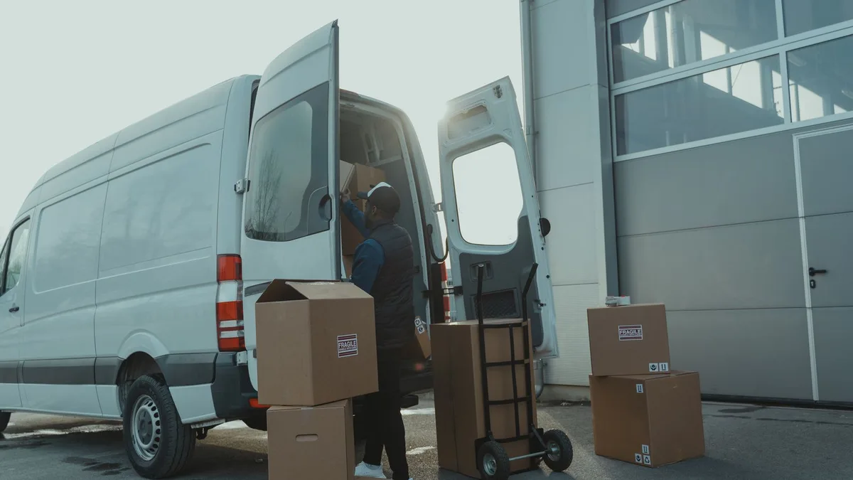 Uniformed worker loading bulky junk into a van during a junk pickup in Dubai