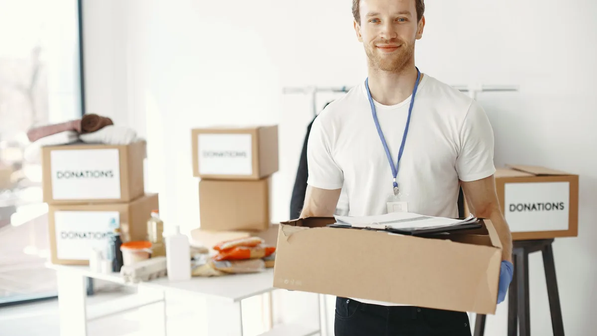 Man packing household items into boxes ready for donation in Dubai
