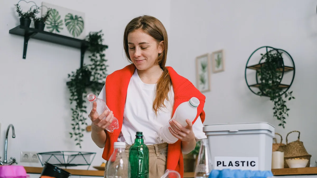 Person sorting plastic bottles for recycling in an apartment kitchen in Dubai