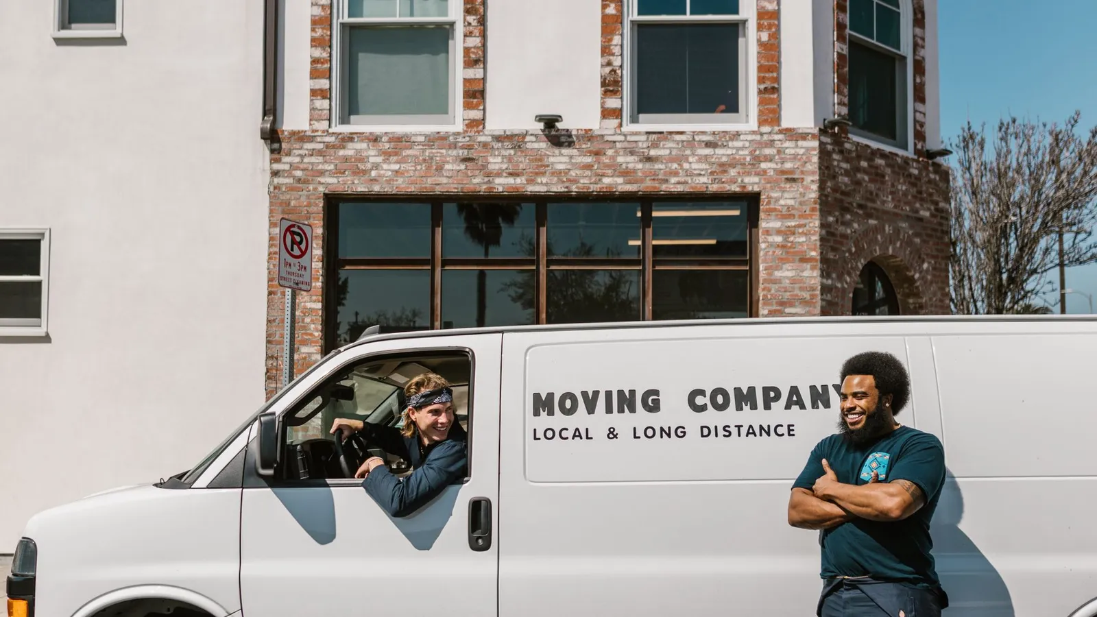 Junk removal crew loading old furniture into a truck outside a Dubai apartment building, illustrating junk removal cost in Dubai