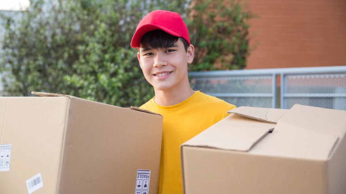 Friendly uniformed local junk removal crew member carrying items during a collection in Dubai