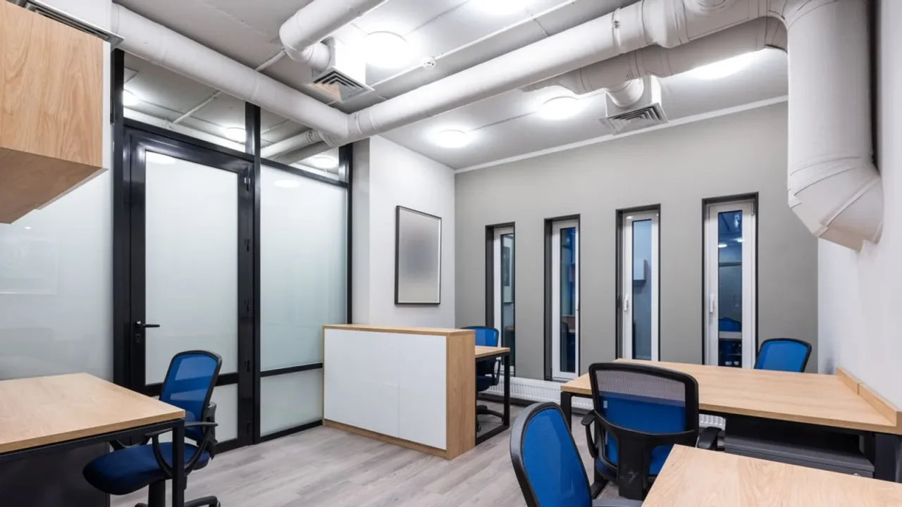 Dubai commercial office with desks, blue task chairs and freestanding reception furniture awaiting landlord clearance