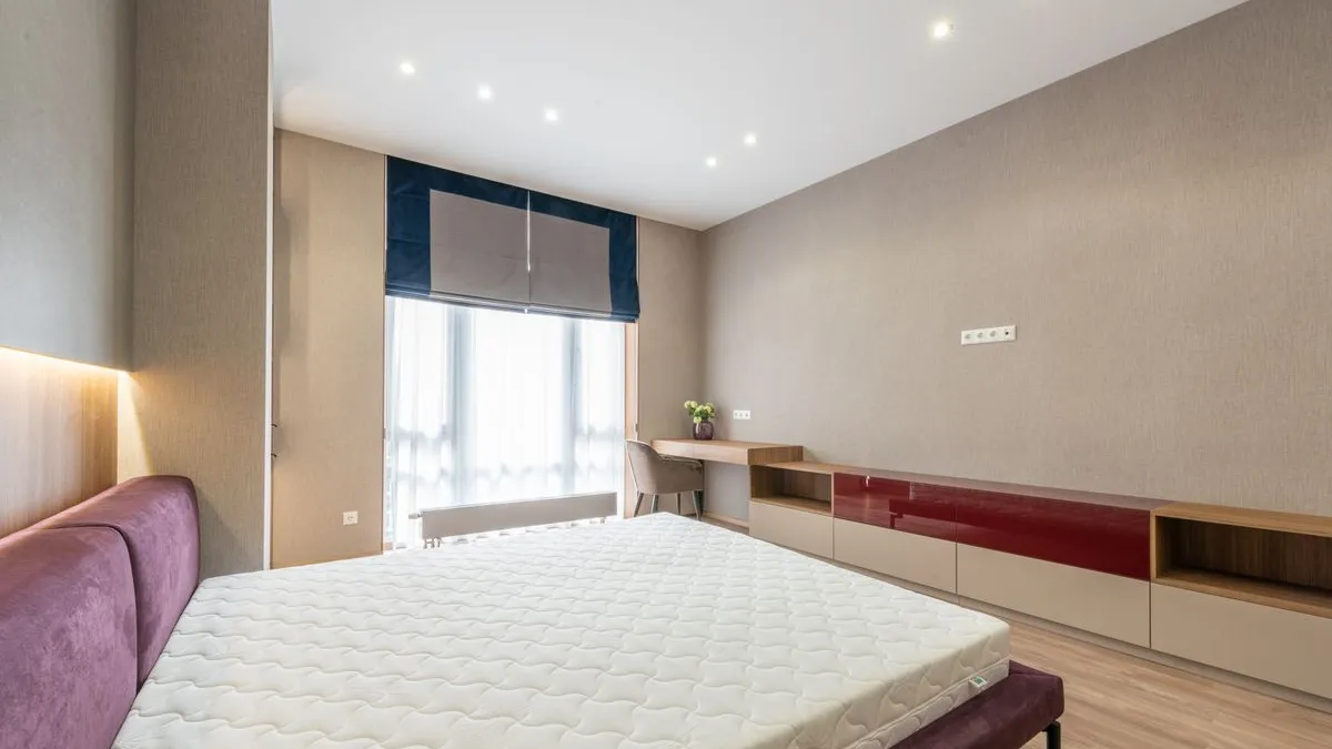 Bare old mattress on a divan base in a Dubai bedroom ready for old mattress removal and pickup