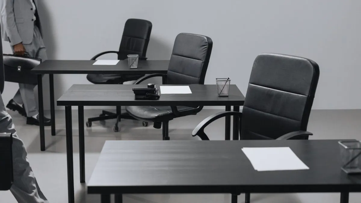 Black leather office chairs at desks in a Dubai workplace being collected during office chair removal