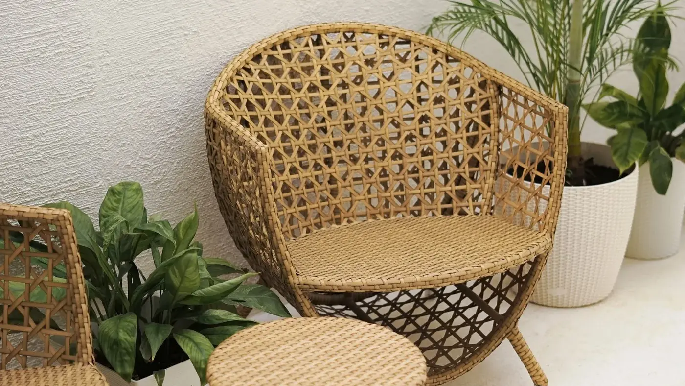 Woven rattan outdoor chair and side table on a villa terrace beside potted palms, ready for outdoor furniture removal