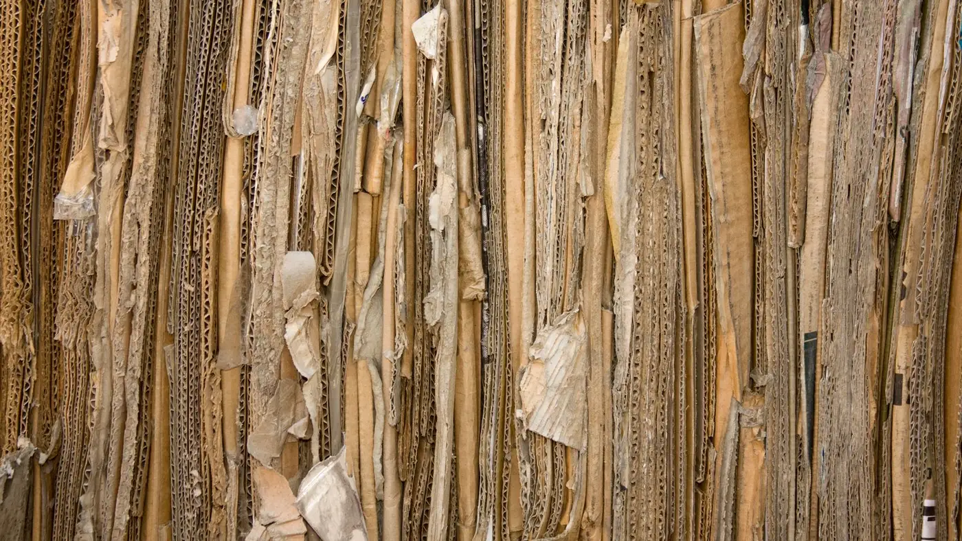 Close-up texture of densely packed flattened cardboard sheets stacked on their edges