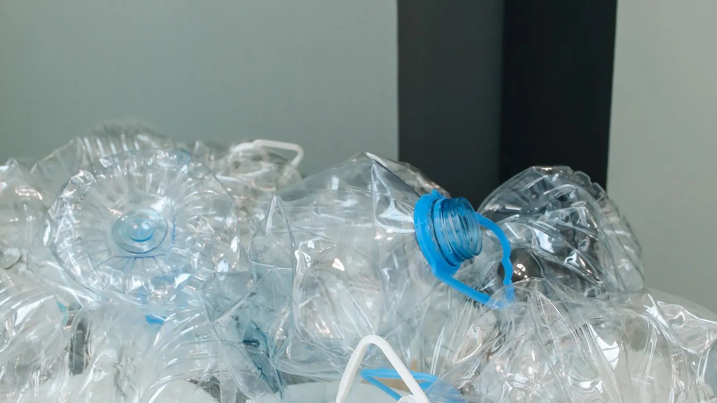 Close-up of crushed and flattened clear plastic water bottles piled together with their caps still on
