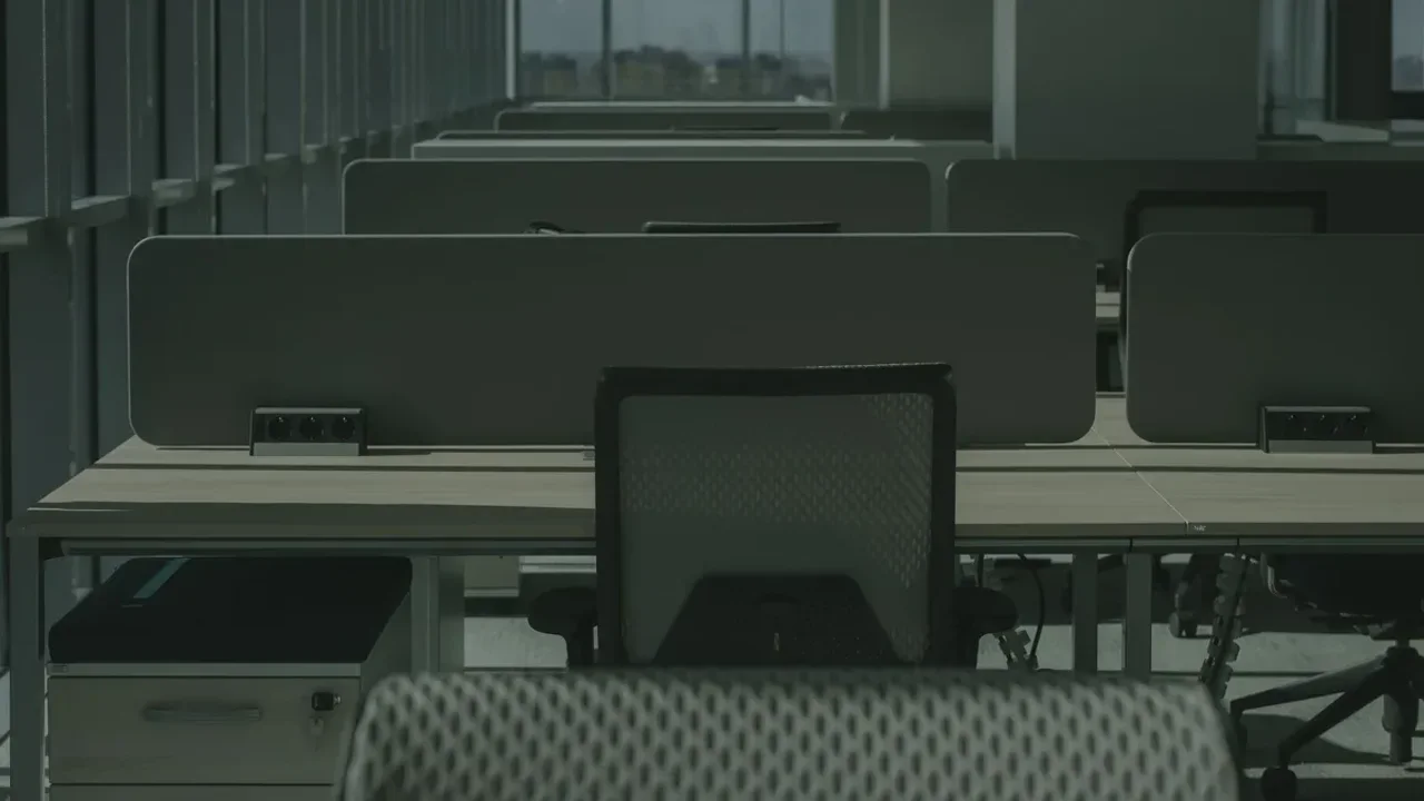 Rows of office workstations, chairs and desk dividers awaiting removal before a Dubai office refurbishment