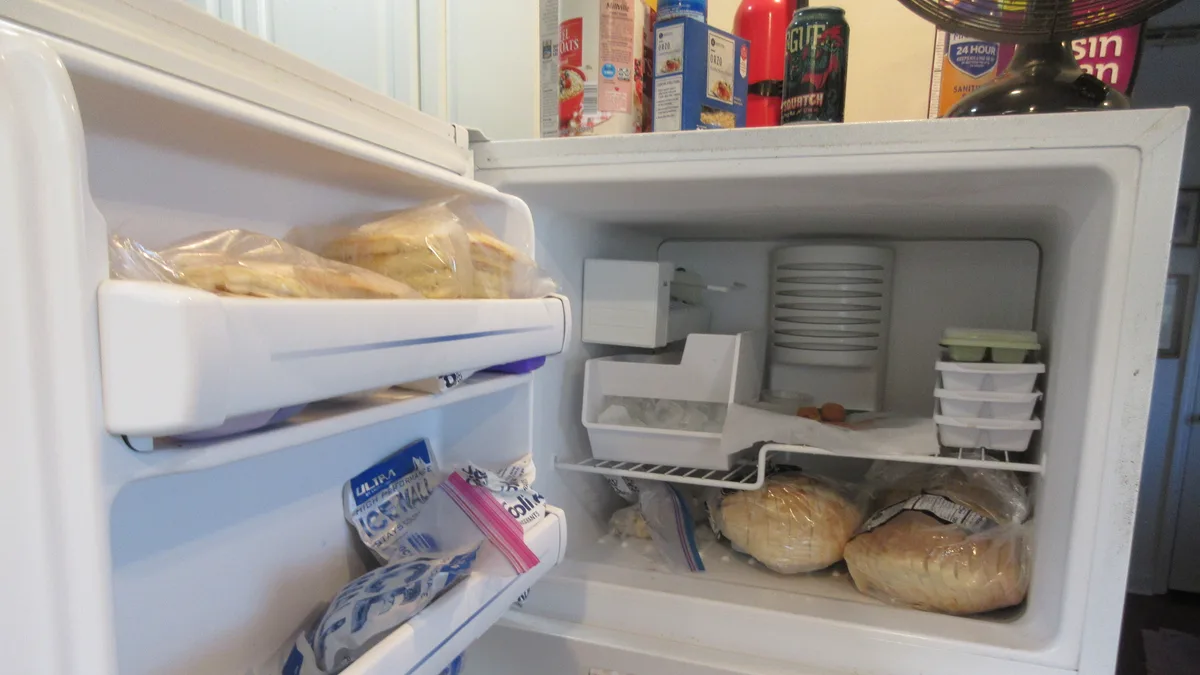 Open refrigerator and freezer being emptied and defrosted before old refrigerator disposal in Dubai