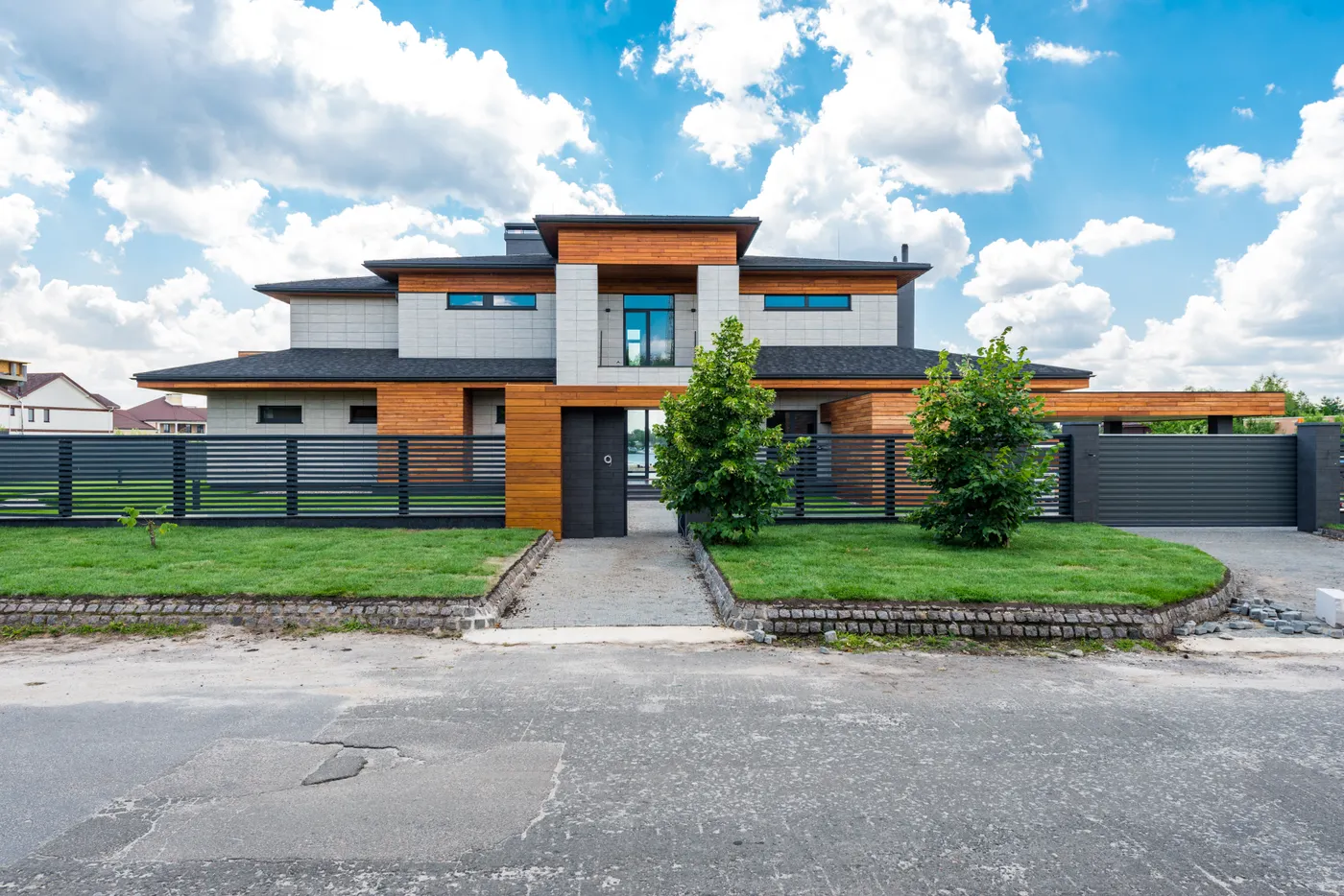 Modern villa exterior with a fenced garden and manicured lawn in a Dubai residential community
