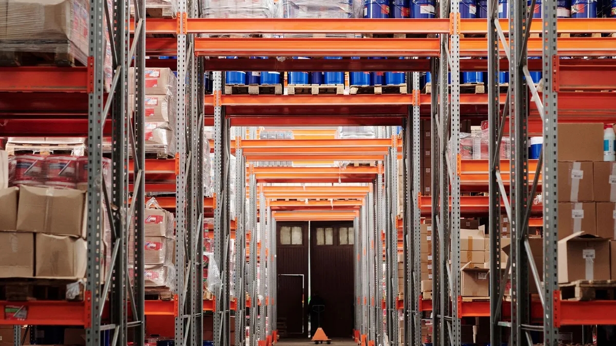 Tall steel pallet racking loaded with boxes and stock in a retail storage warehouse