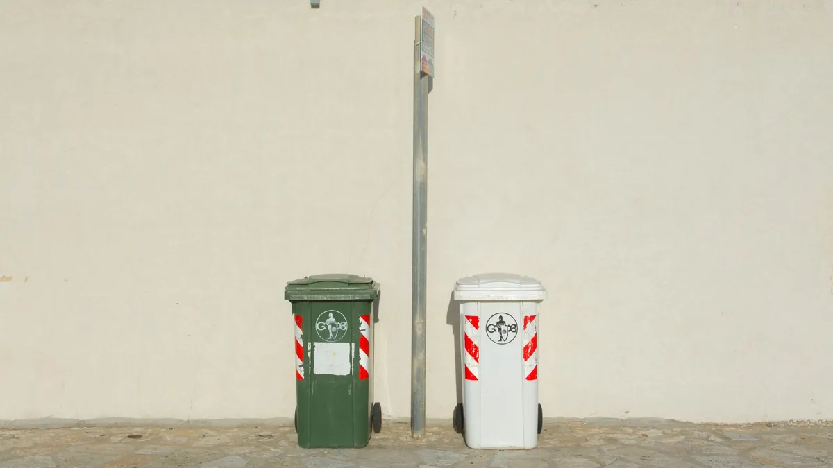 Household rubbish bins beside a wall outside a Dubai home, ready for scheduled household rubbish collection