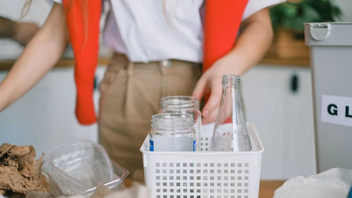 Glass bottles and jars being sorted into recycling containers during responsible rubbish collection in Dubai