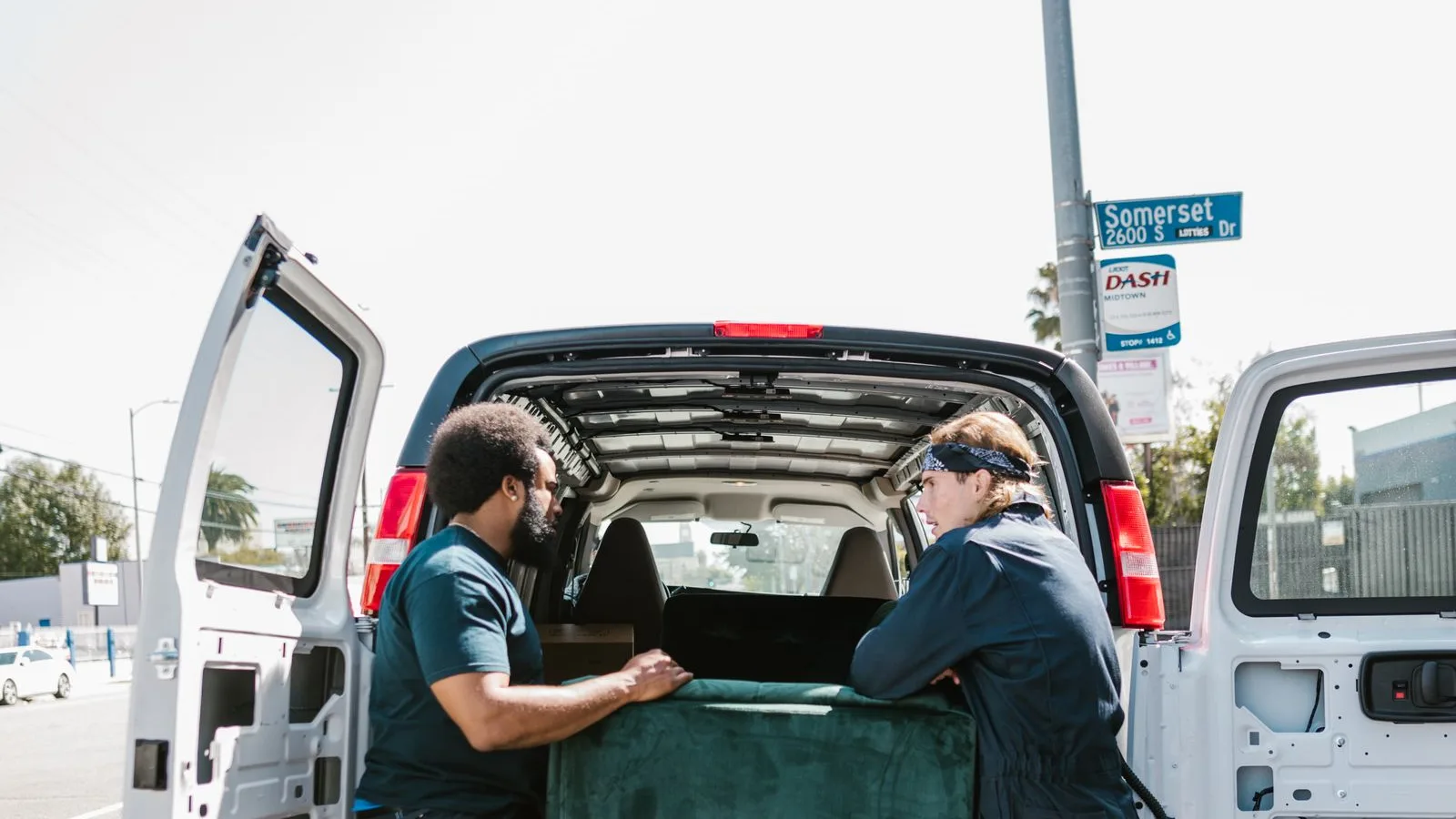 Two-person crew loading an old sofa into a van for same day junk removal in Dubai