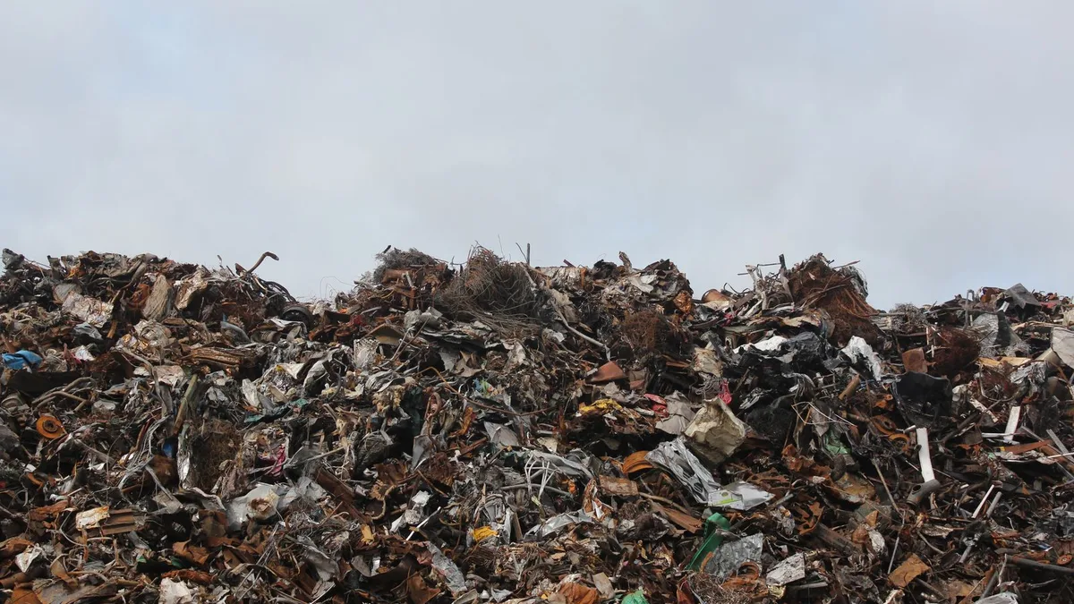 Large pile of mixed scrap metal at a recycling yard under an overcast sky