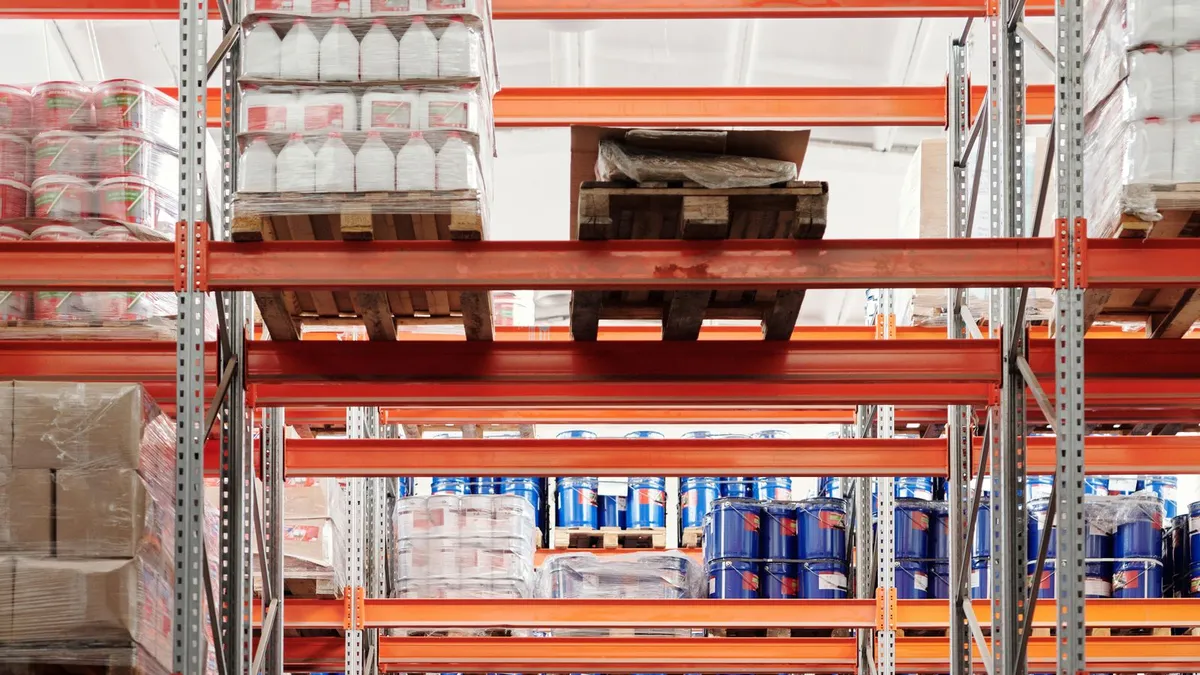 Tall industrial pallet racking and shelving in a Dubai warehouse being cleared during a commercial cleanout