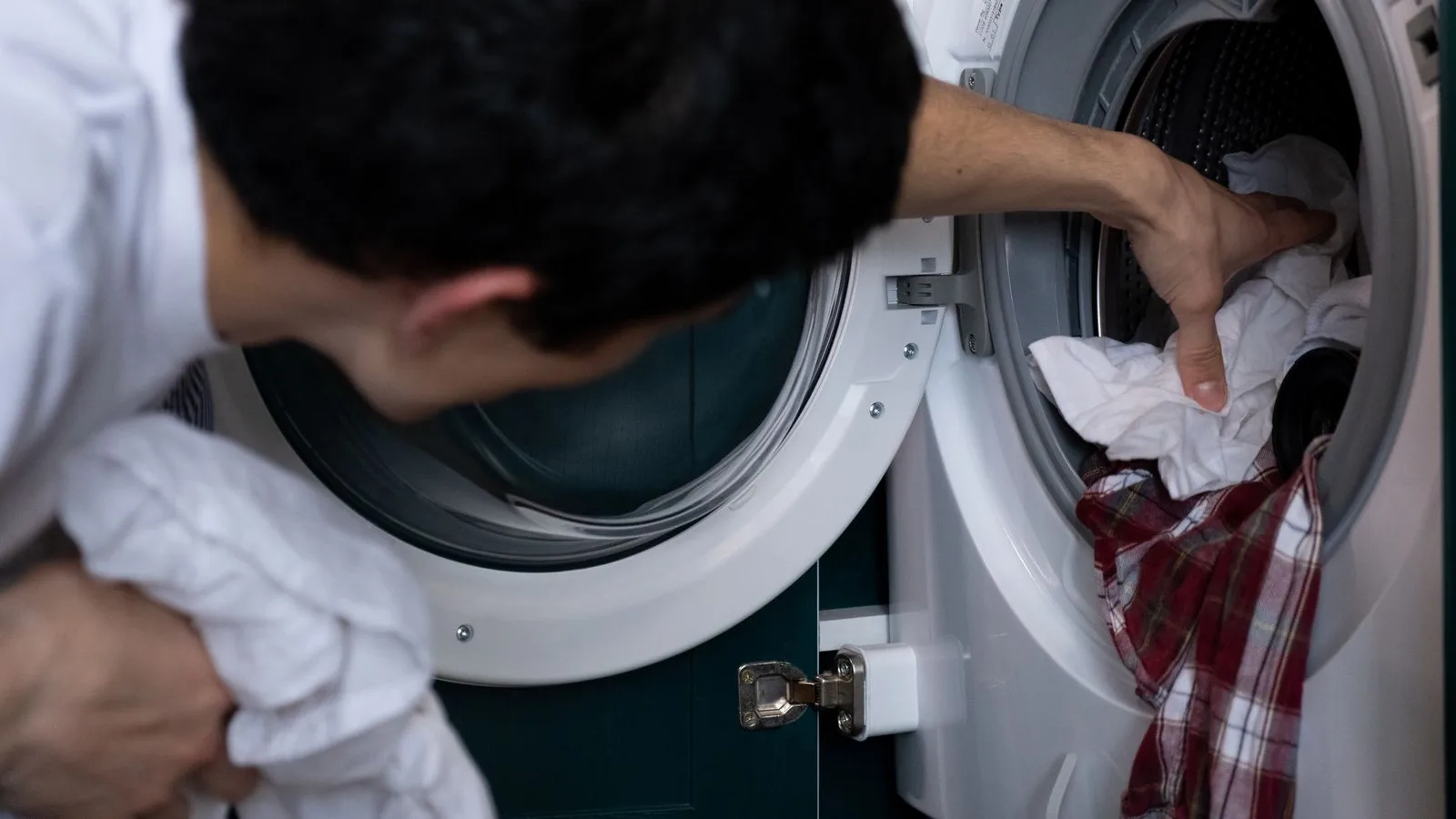 Front-load washing machine in a Dubai home being emptied and prepared for professional washing machine removal