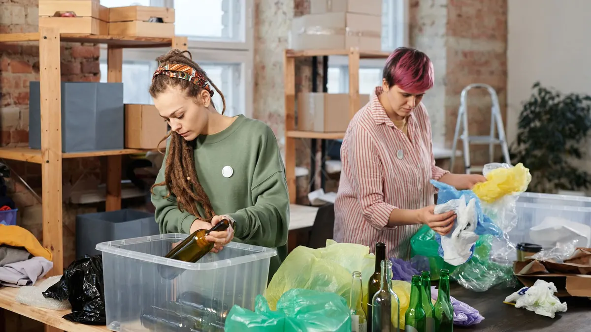Waste collection team sorting recyclable glass, plastic and packaging into separate bins in Dubai